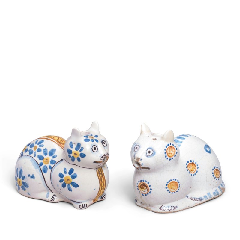 Two zoomorphic Nevers faience pouring vessels modelled as recumbent cats, late 17th century
