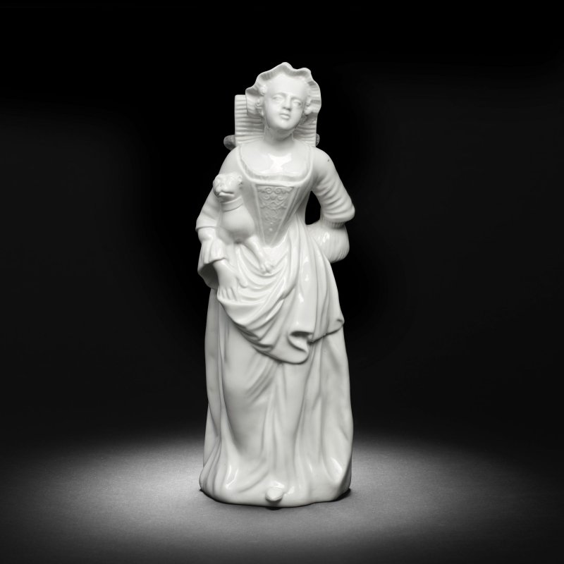 A Chantilly white figure of a lady with a basket and pug (Hotteuse), mid 18th century
