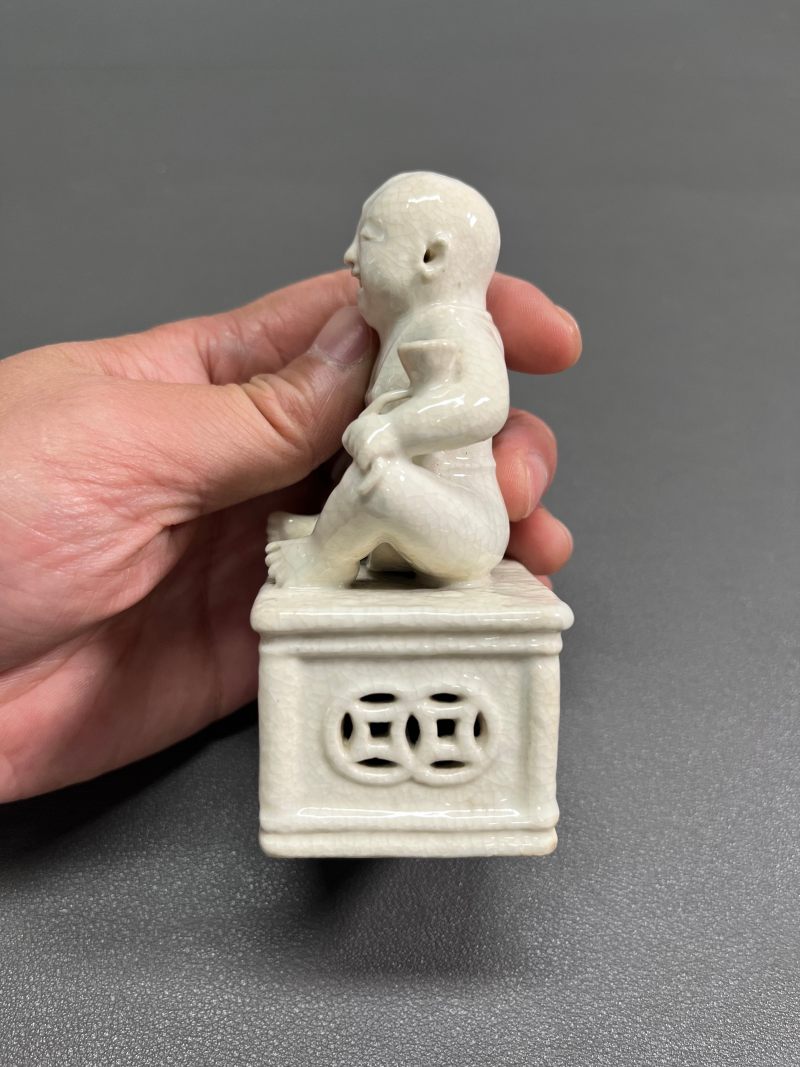 清乾隆 仿定白釉童子坐像 - 图4
