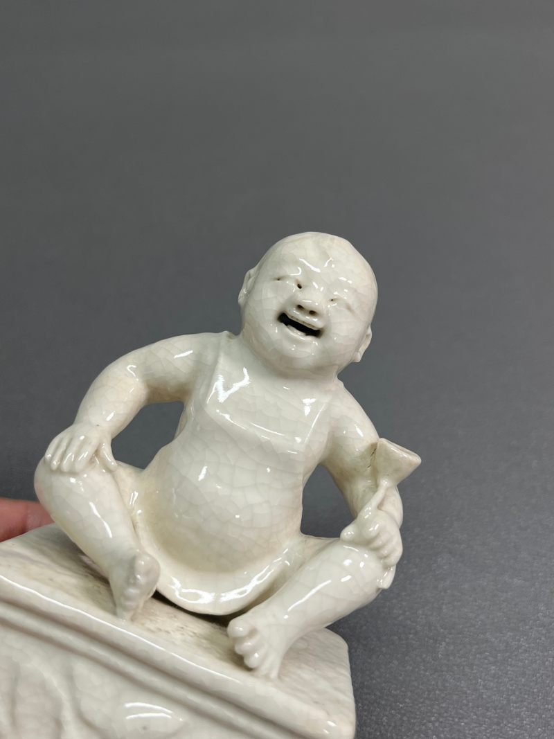 清乾隆 仿定白釉童子坐像 - 图7