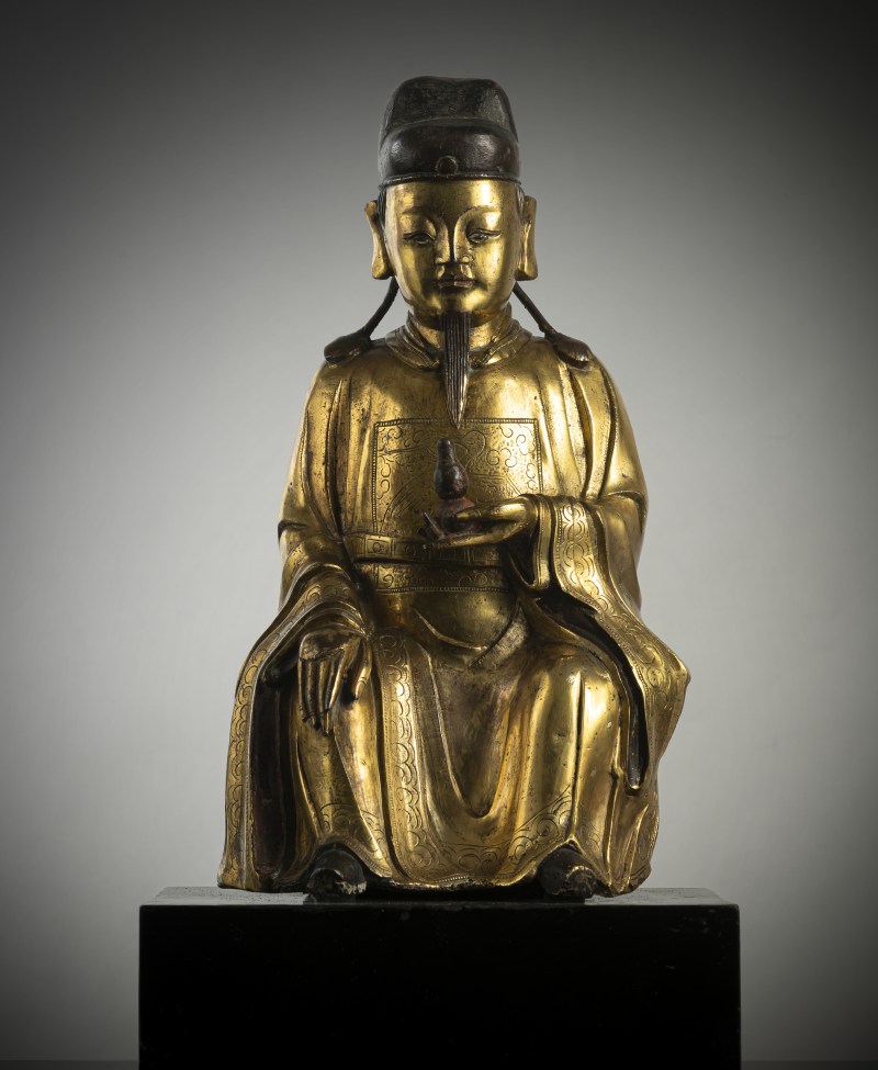 A GILT-BRONZE FIGURE OF A DIGNITARY