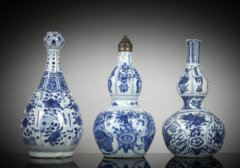 Three porcelain bottle vases decorated in underglaze blue, one with an Ottoman lid, partly decorated in the Kraak style