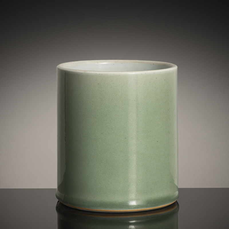 A cylindrical porcelain celadon brush pot