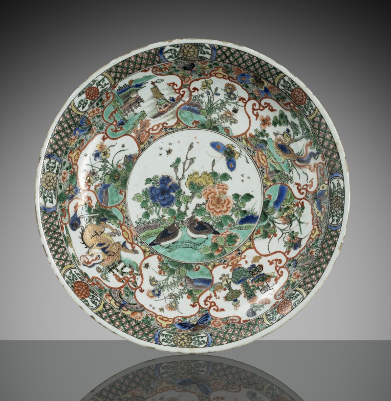 A large 'famille verte' porcelain charger featuring a pair of quails alongside flowers and butterflies, surrounded by a border of flowers and animals