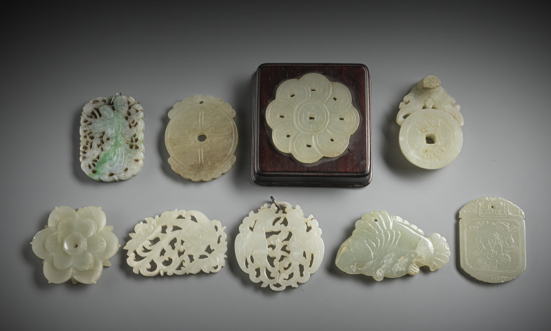 A group of nine jade carvings, some pendants, one mounted in wood