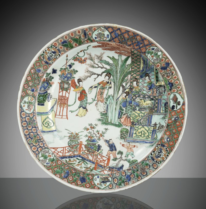 A large 'Famille verte' plate depicting a scene of beautiful women and children in a garden with a terrace