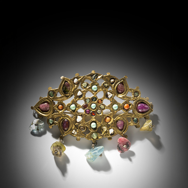 A gemstone-inlaid plaque reworked as a brooch
