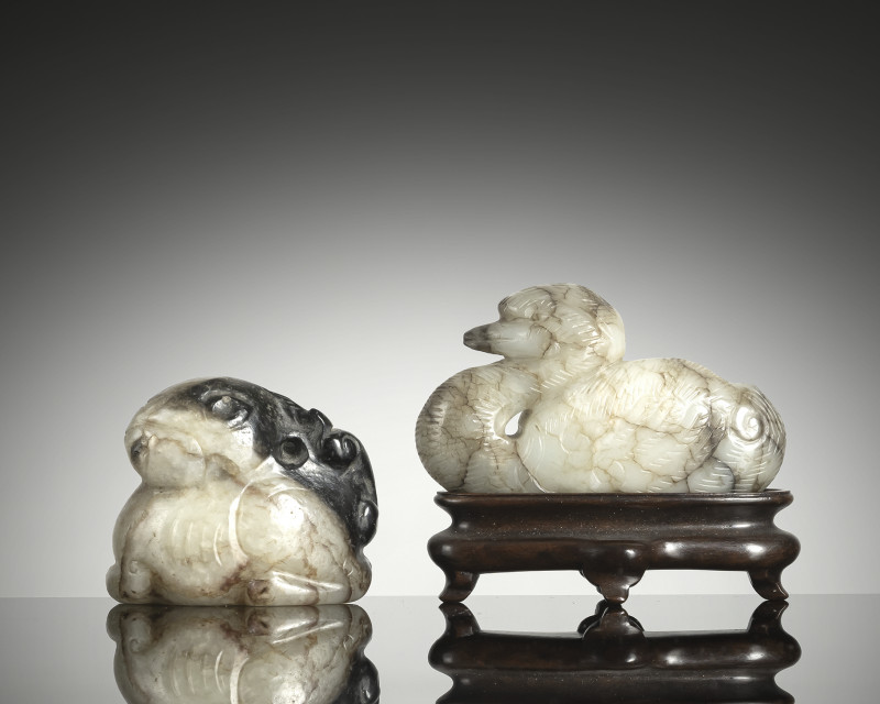 Two jade carvings: Reclining duck and seated hare made of green jade, partly with black inclusions