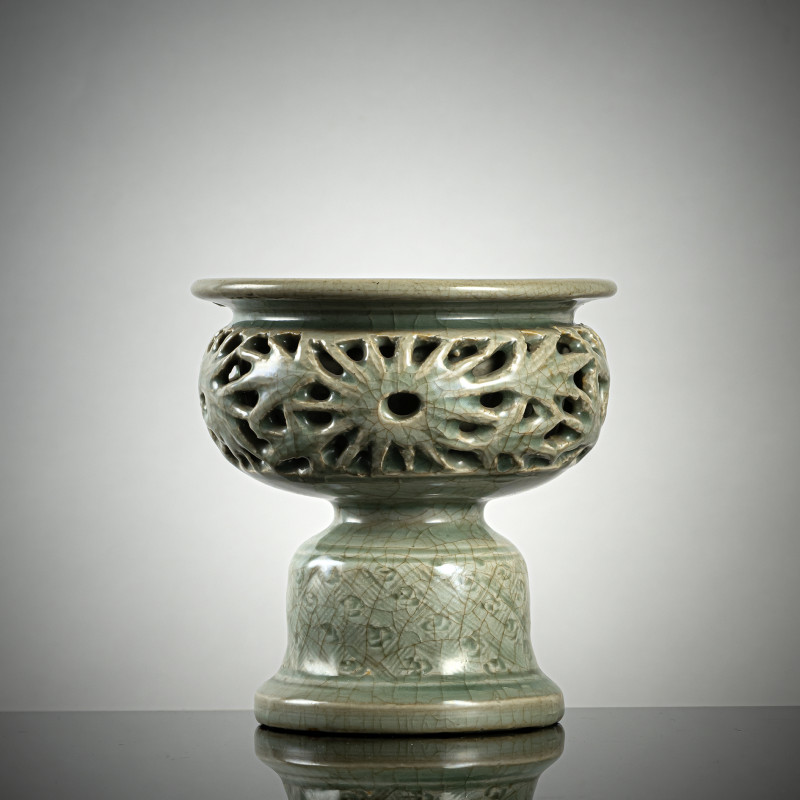 A rare celadon-glazed oil lamp with openwork wall with floral decoration