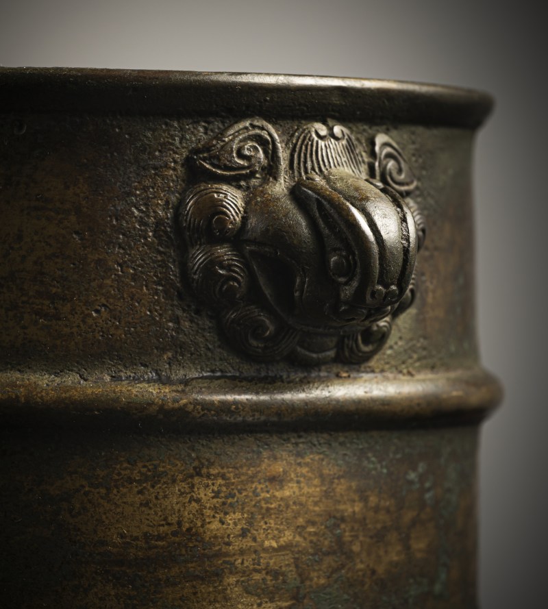 A cylindrical bronze incense burner in the shape of a cylindrical 'Lian' with relief burrs and mask handles on the sides - 图5