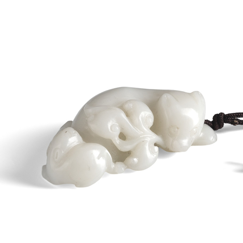 A white jade pendant in shape of a recumbent cat with young