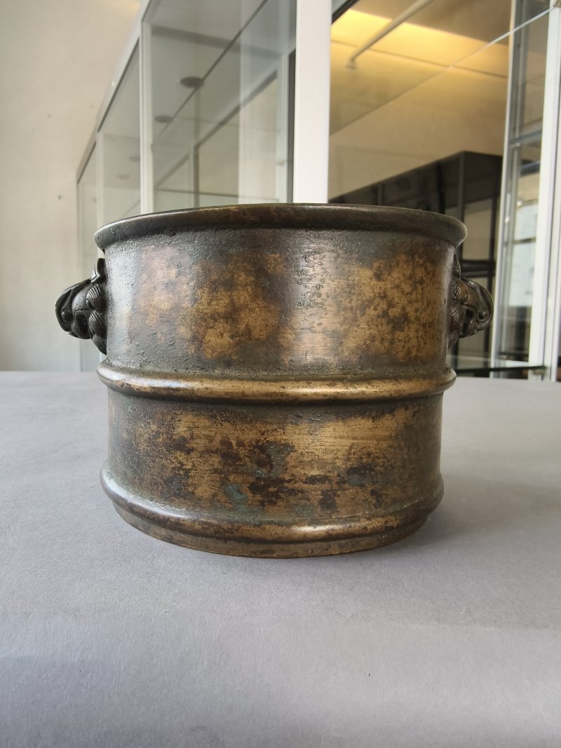 A cylindrical bronze incense burner in the shape of a cylindrical 'Lian' with relief burrs and mask handles on the sides - 图10