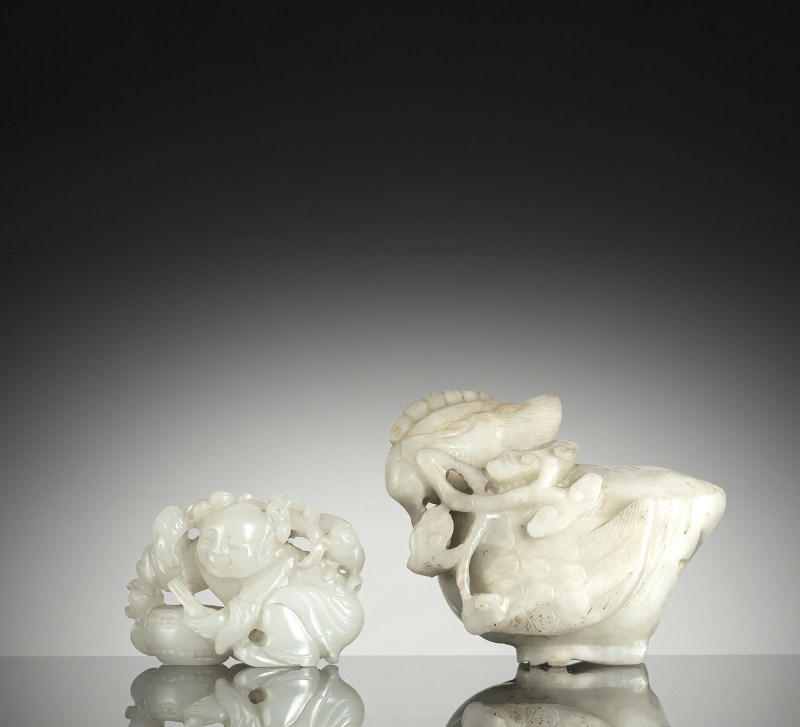 A brrush washer in the shape of a duck and carving of a boy in almost white and light green jade