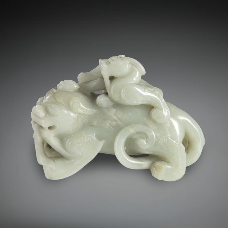 A fine jade carving of a 'bixie' with a boy in light green and white jade