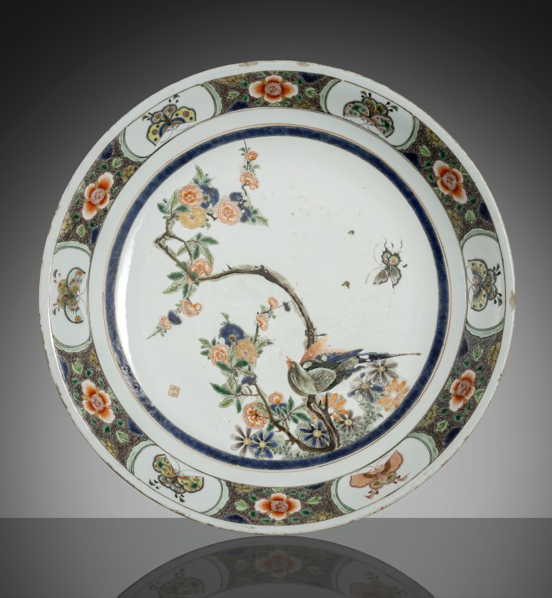 A large 'Famille verte' plate with decoration of a magpie on a flowering branch with butterfly and seal