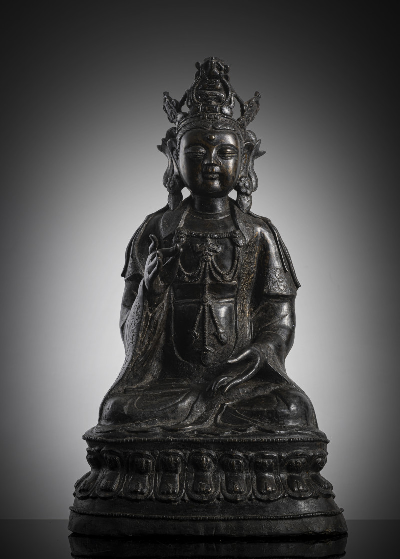 A large bronze figure of Guanyin seated on a lotus pedestal