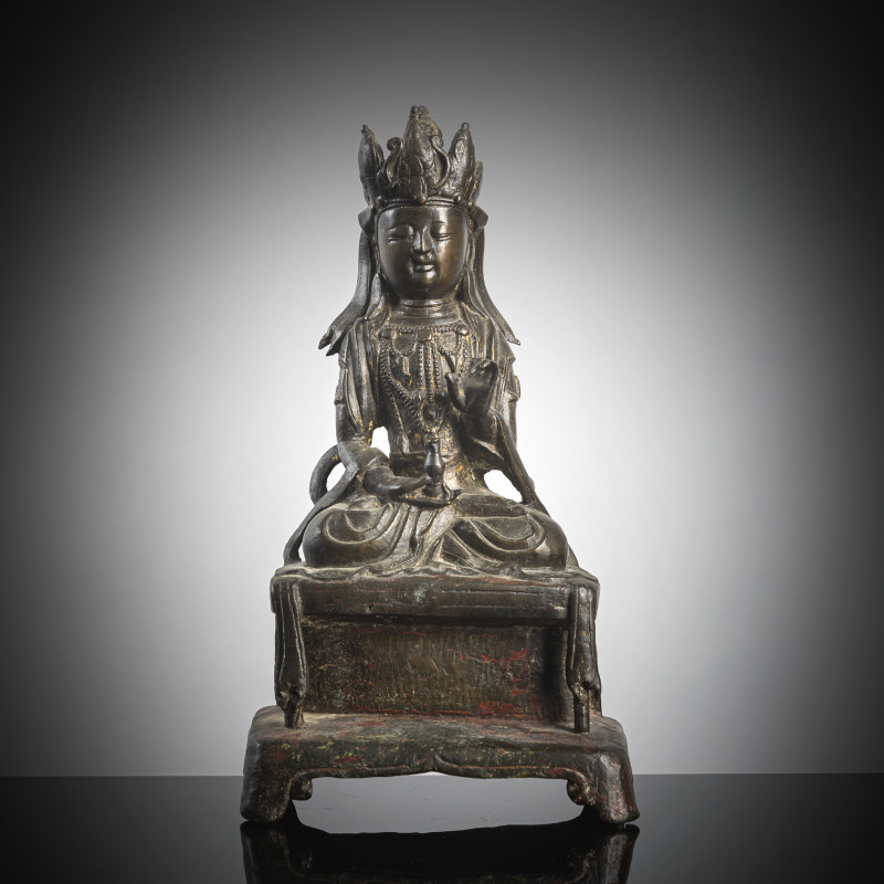 A bronze figure of Guanyin on a throne