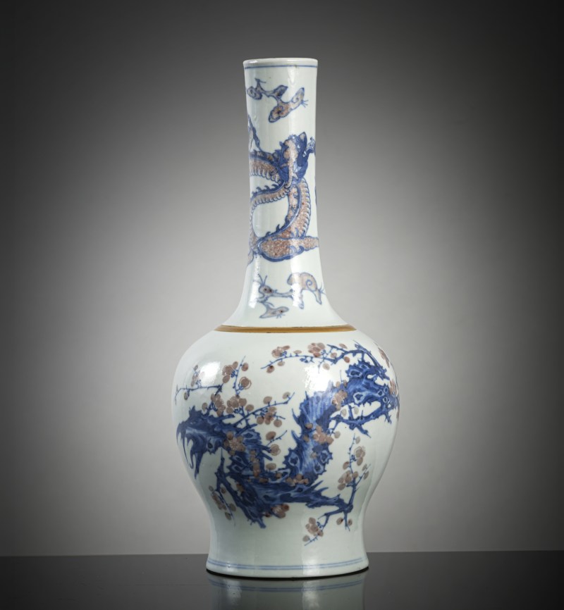A bottle vase with copper-red and underglaze blue decoration of plum blossom branches, lingzhi and chilong