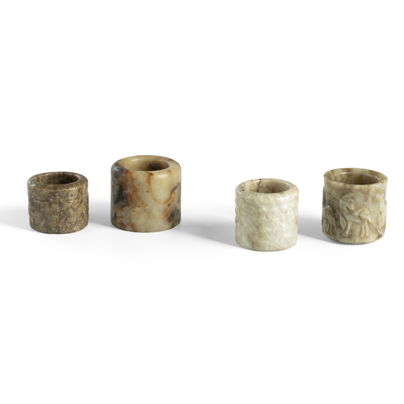 A group of four jade archer's thumb rings, some with relief decoration