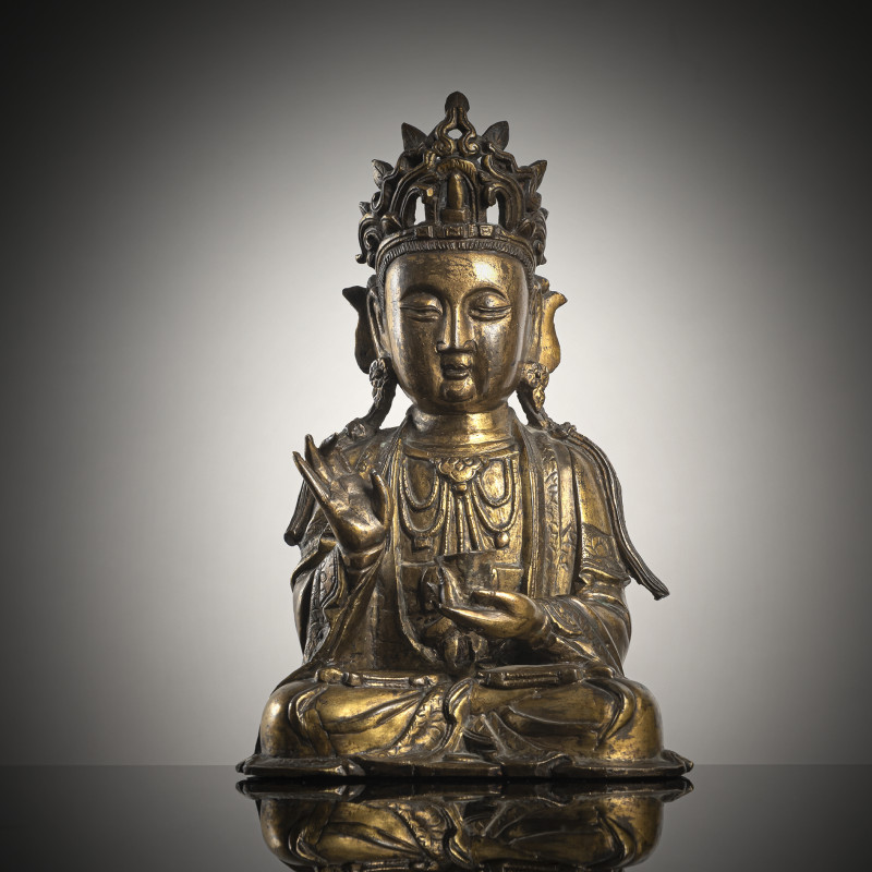A gilt-bronze figure of Guanyin sitting in meditation, right hand raised