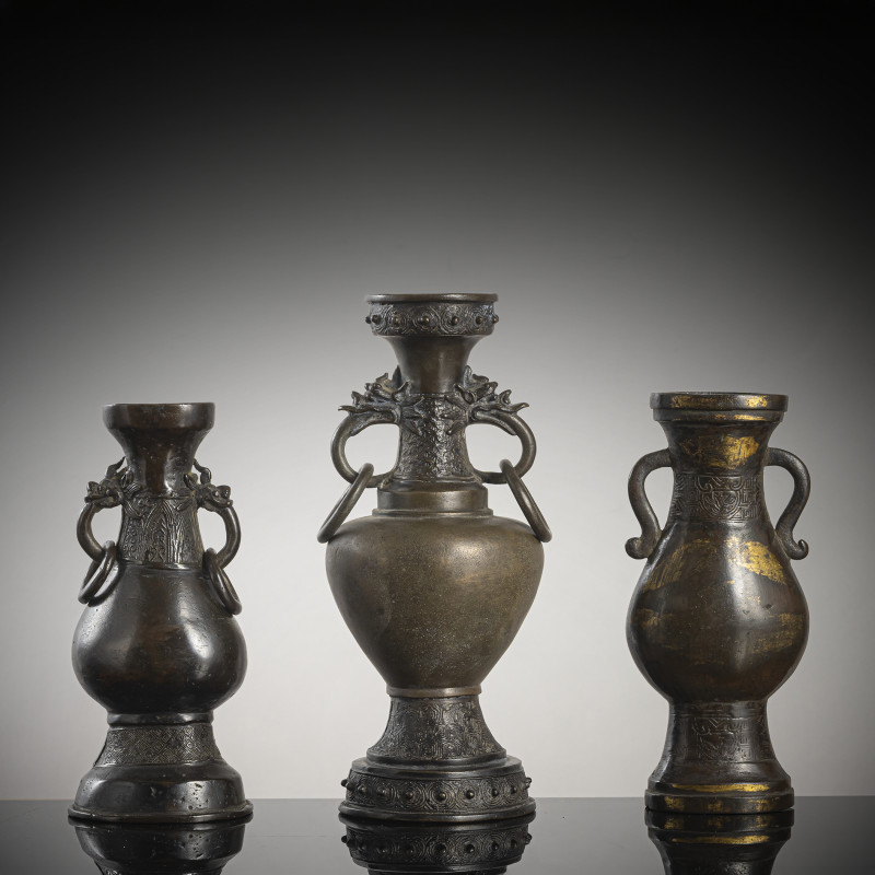 A group of three bronze vases, one with partial fire gilding