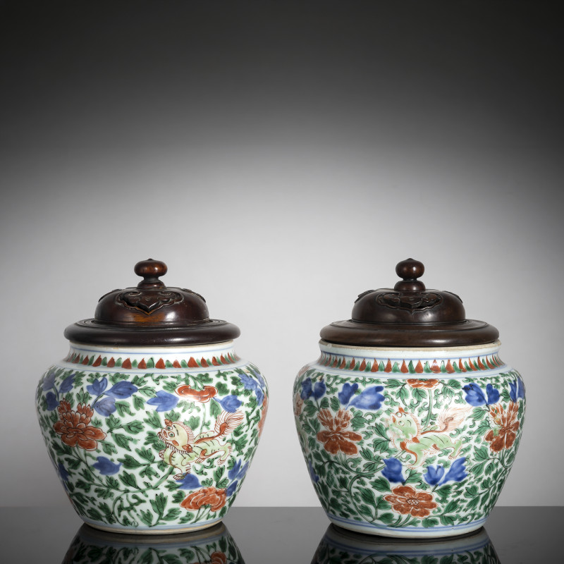 Two 'Wucai' jars with floral decoration and wooden lids
