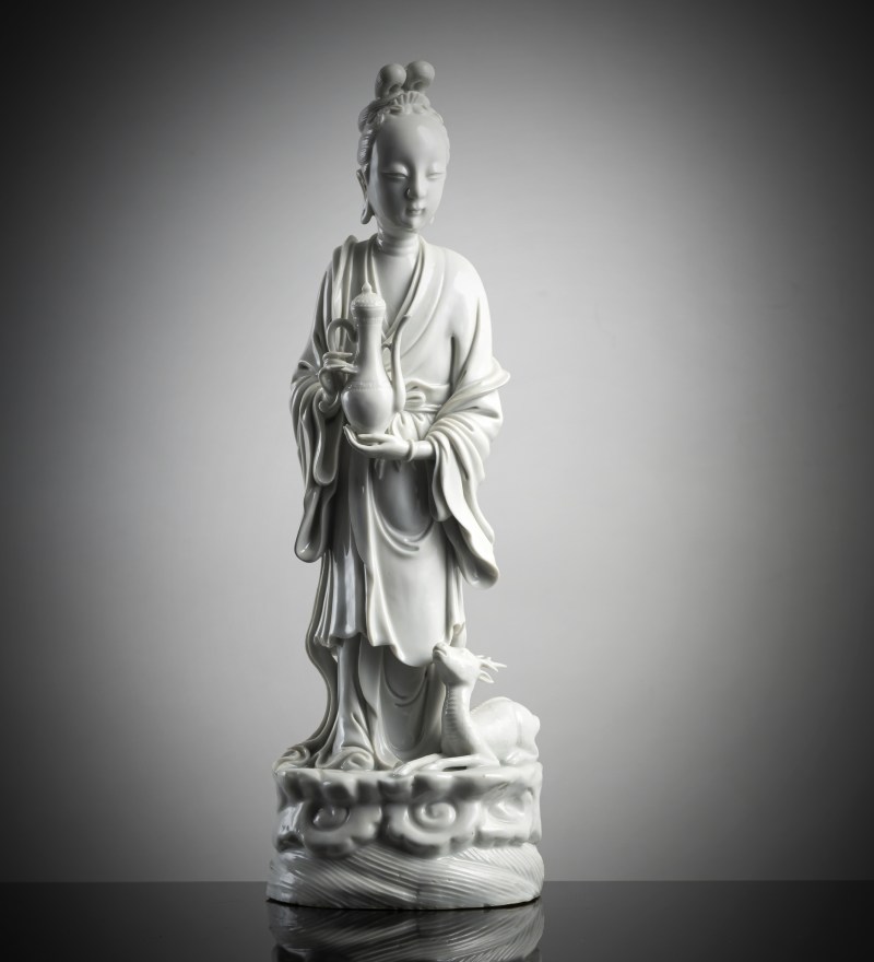 A Dehua figurine of an immortal with a deer and a jug