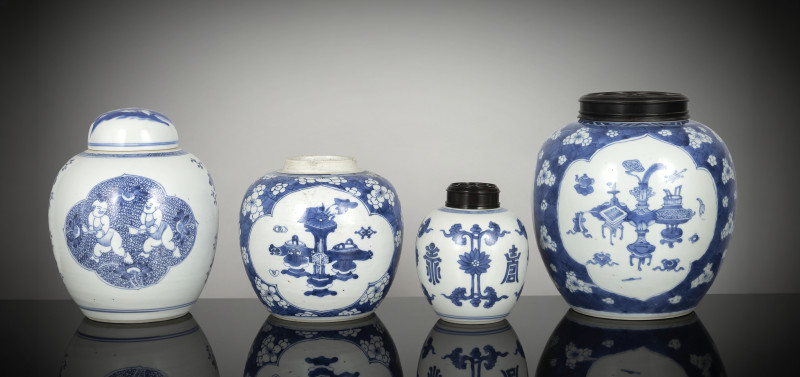 Four porcelain ginger jars decorated in underglaze blue, one with a porcelain cover and two with wooden covers