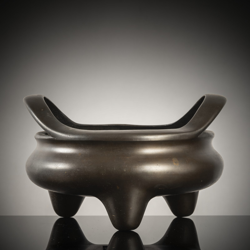 A tripod bronze incense burner with handles on the rim