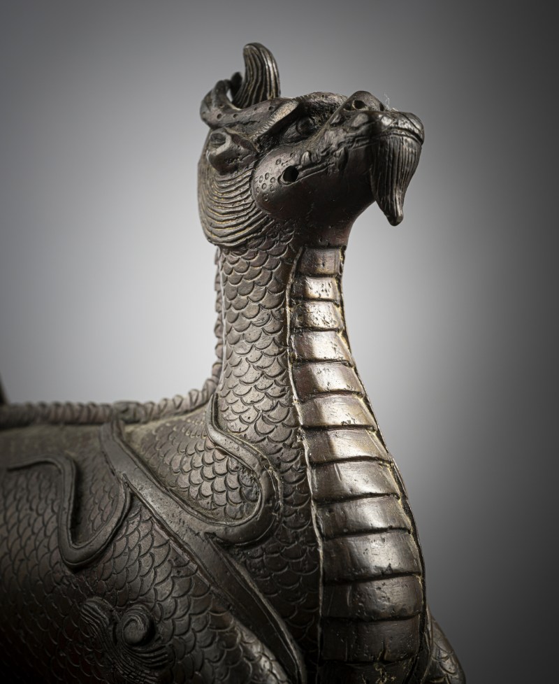 A bronze of a reclining mythical creature on a wooden stand - 图5