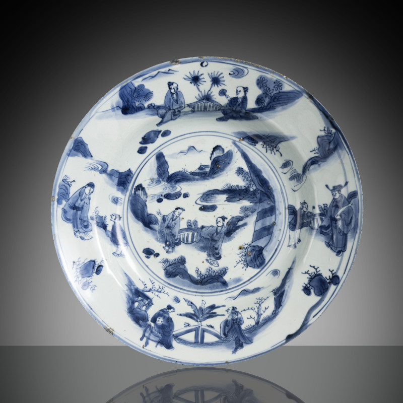 A blue and white porcelain plate with scholarly scenes