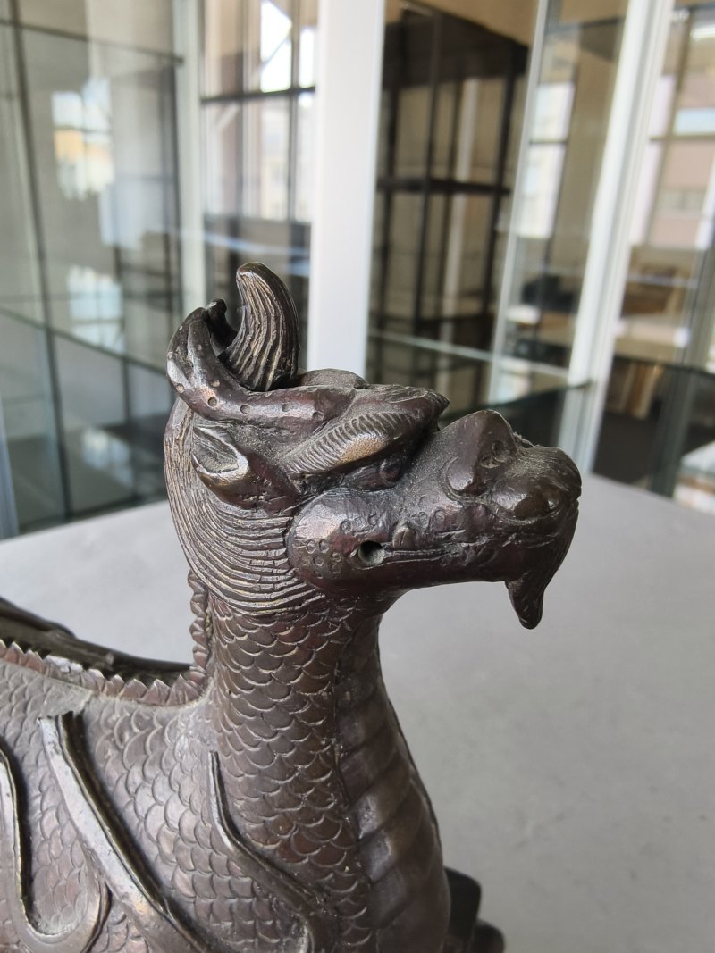 A bronze of a reclining mythical creature on a wooden stand - 图15