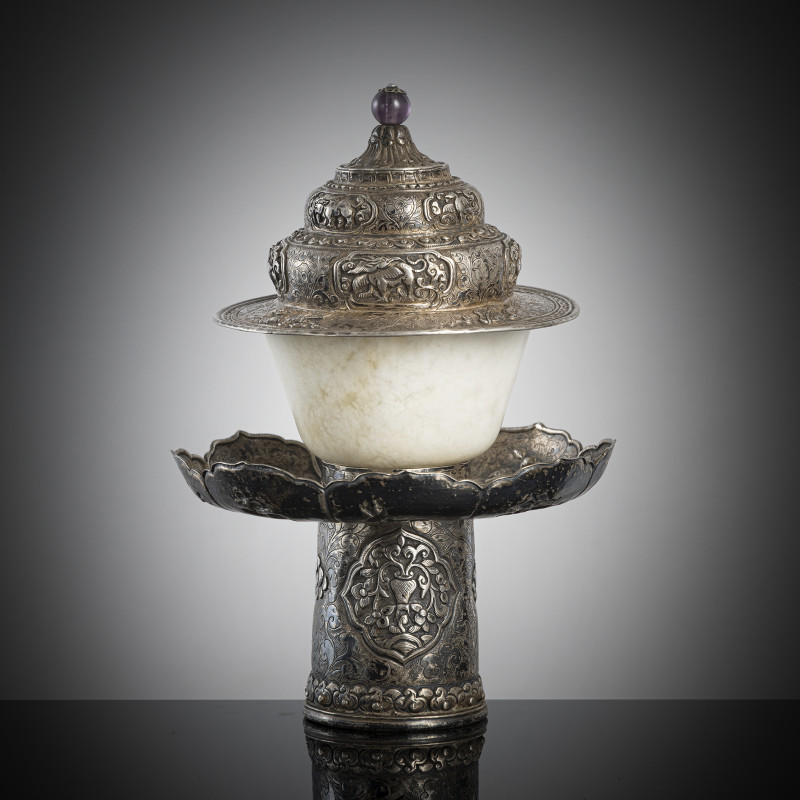 A jade bowl with stand and cover in silver with animals and floral motifs in relief