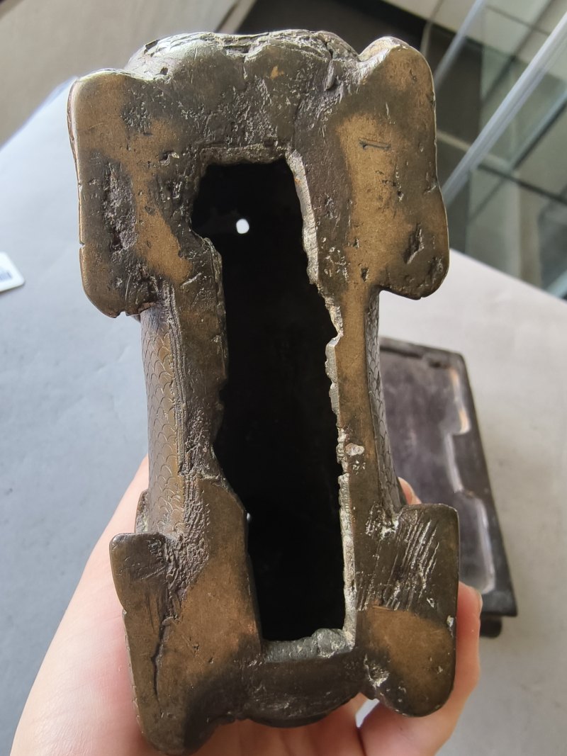 A bronze of a reclining mythical creature on a wooden stand - 图6