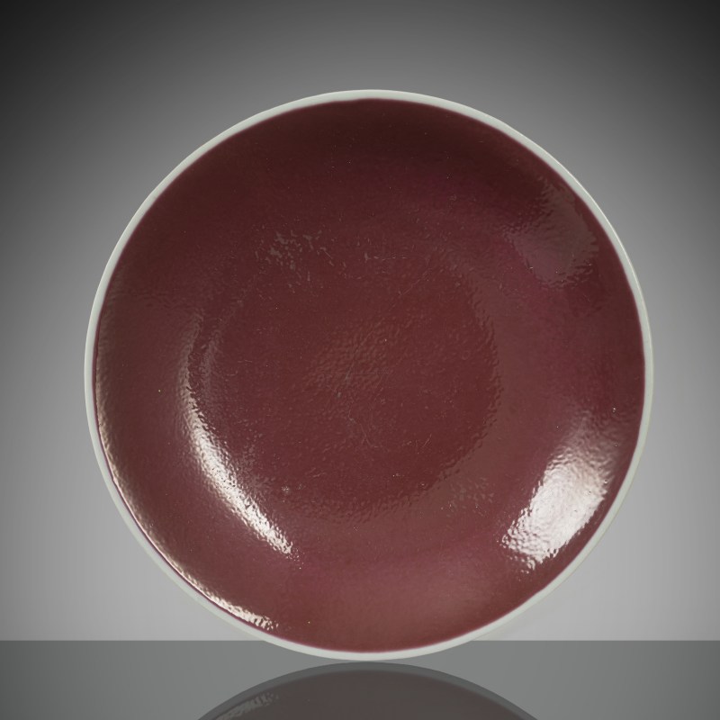 A porcelain plate with a cyclamen-coloured glaze