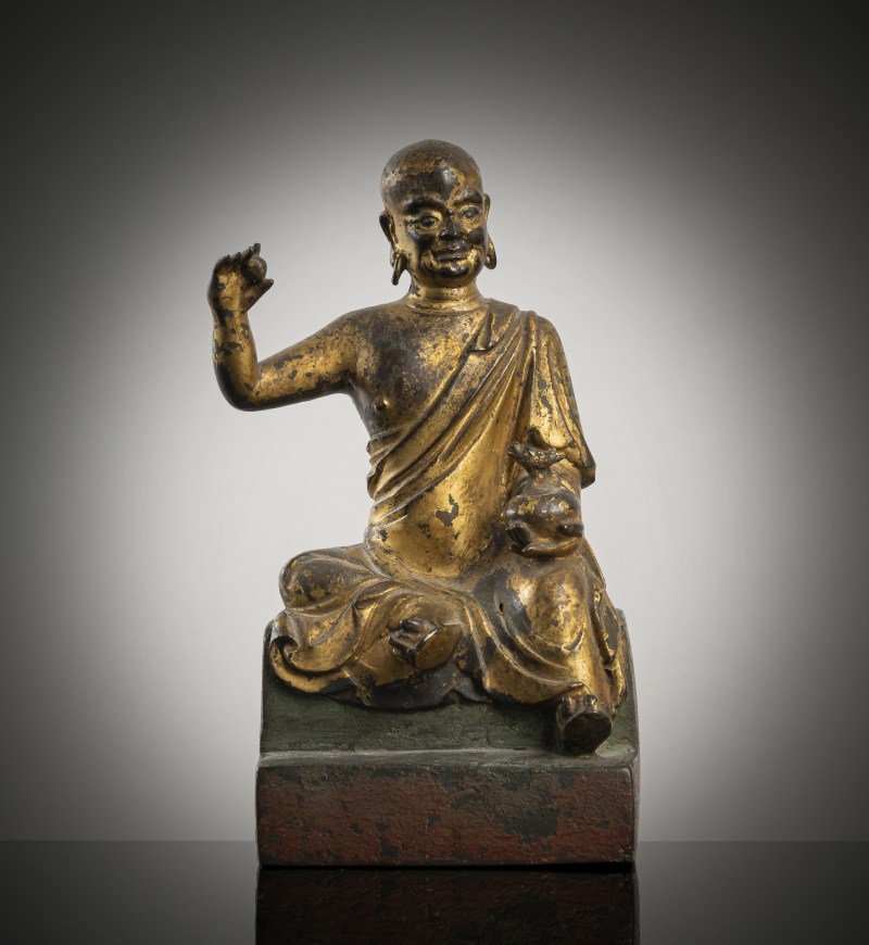 A gilt- and red-lacquered bronze figure of a luohan