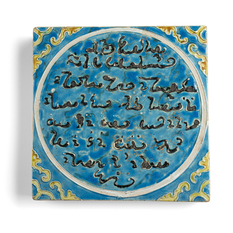 A tile with calligraphy on a blue background with yellow tendrils
