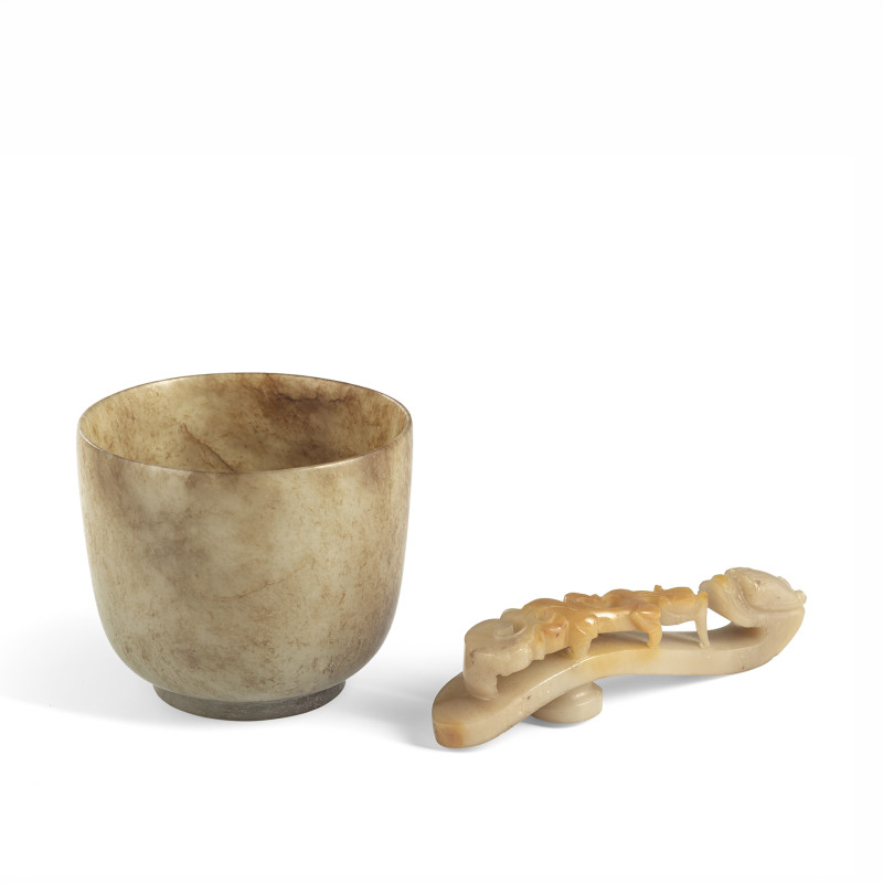 Three carvings made of jade or agate, including a caramel-coloured jade cup and a belt hook