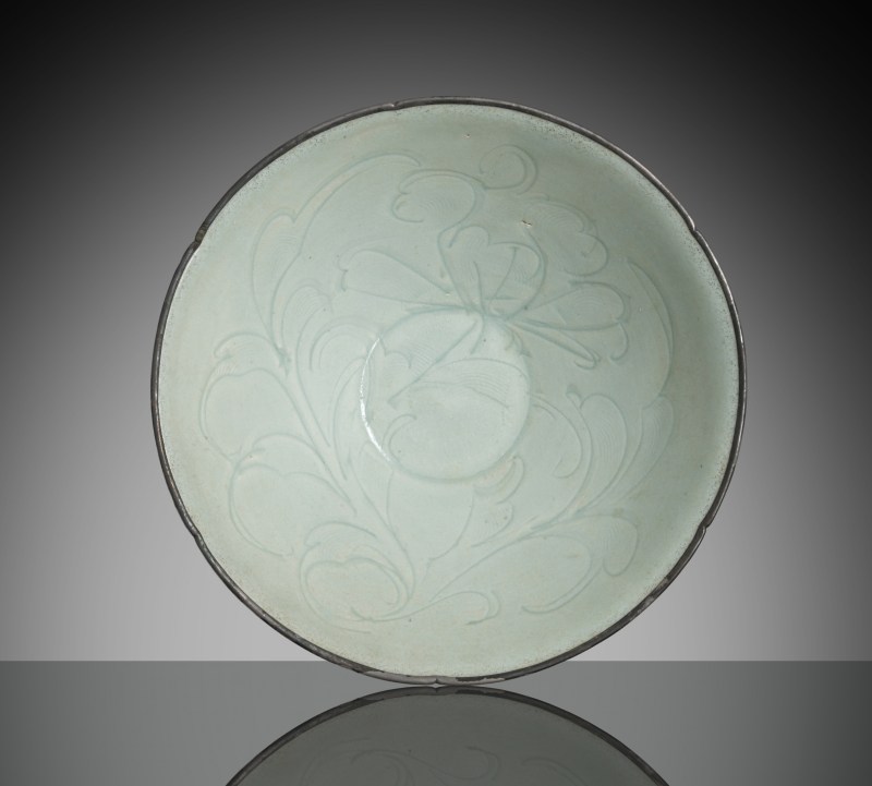 A slightly floriform 'qingbai' bowl with carved floral decoration and mounted silver rim