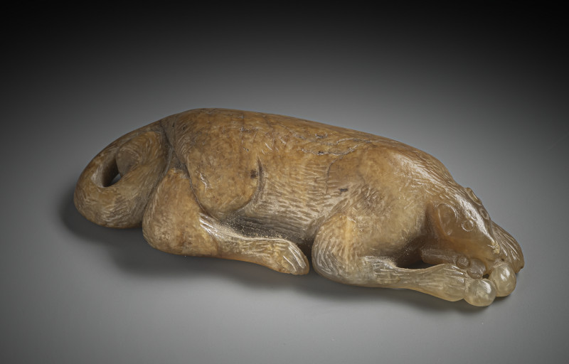 A reclining squirrel with grapes on a wooden stand