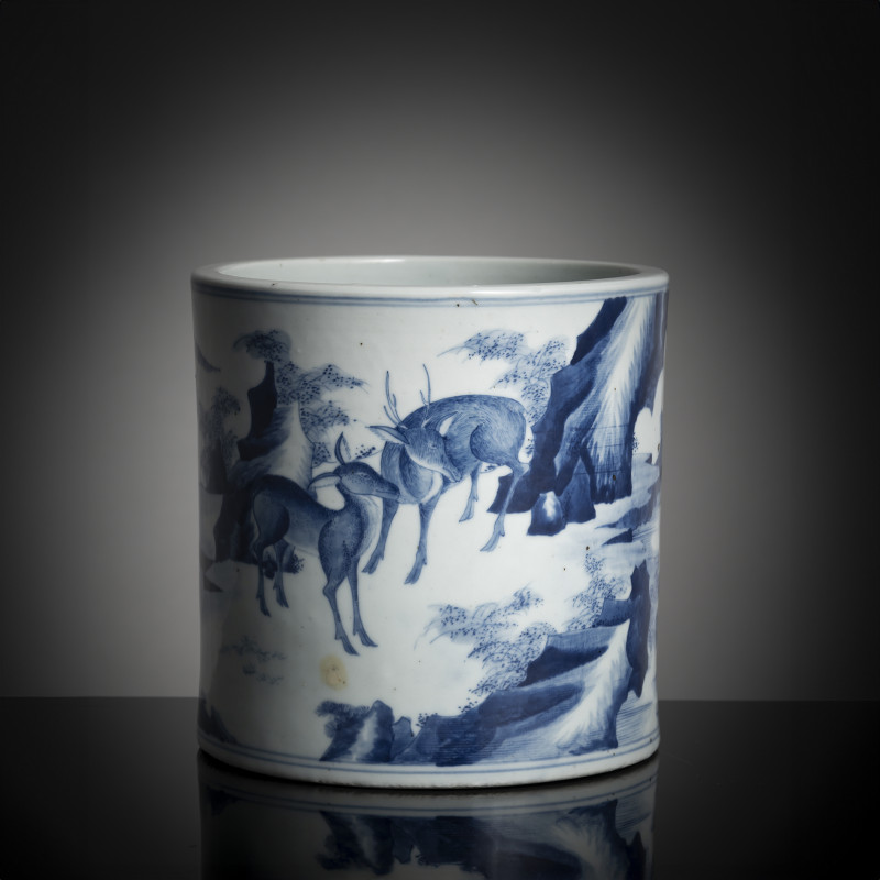 A blue and white brush pot with deer in a landscape