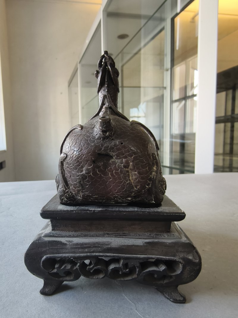 A bronze of a reclining mythical creature on a wooden stand - 图14