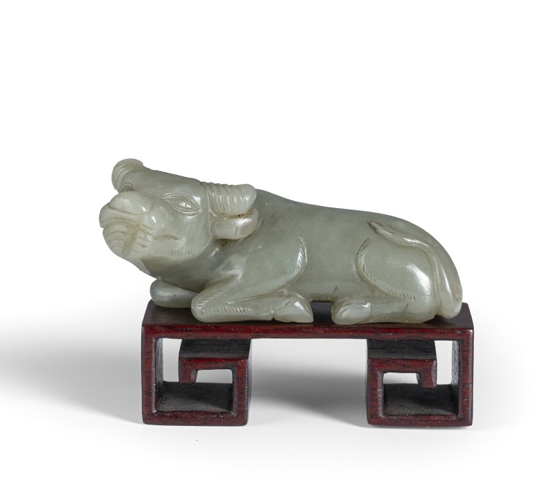 A light green jade carving of a lrecumbent ox