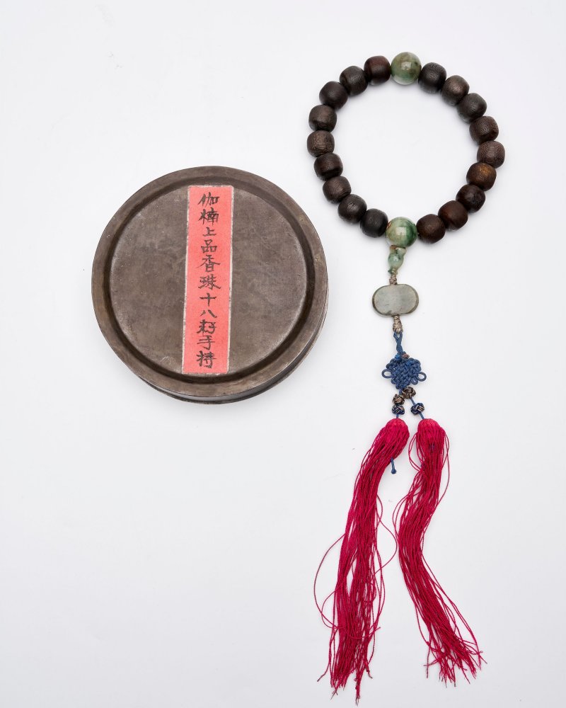 二十世紀 沉香木十八籽手持 翠玉記念、墜 錫盒，銘⌈聚盛⌋、⌈點銅⌋，簽⌈迦楠上品香珠十八籽手持⌋ | AN ALOESWOOD BEADED BRACELET - 图1