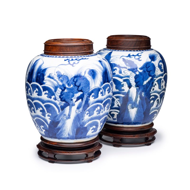 A pair of Chinese blue and white 'Mythical Beast' jars with later wooden covers and stands - 图1