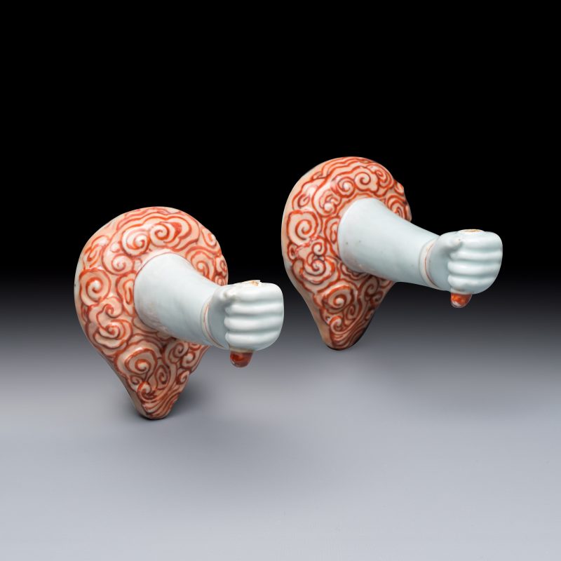 A pair of Chinese iron-red and gilt-decorated wall sconces in the shape of an arm