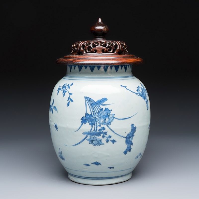 A Chinese blue and white vase with floral design and a later wooden cover