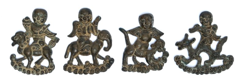 Four small bronze appliques of boys on animals