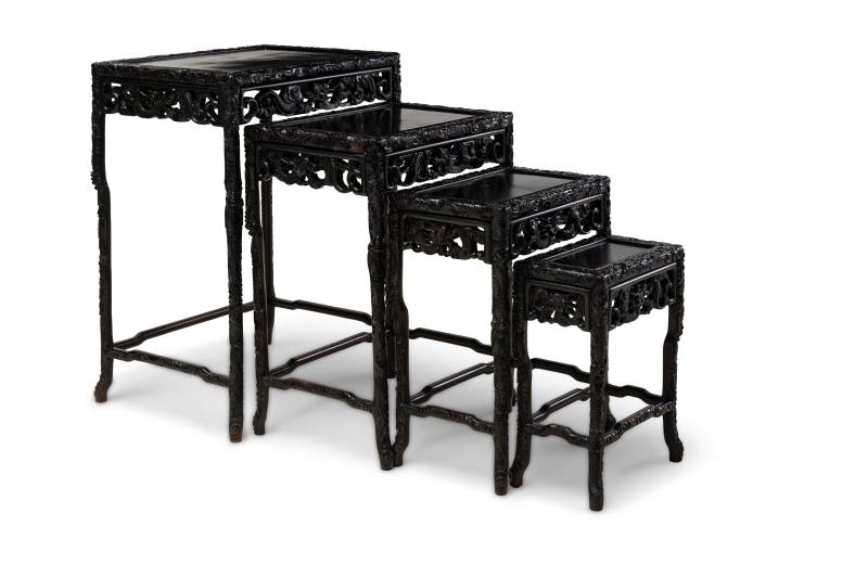 A set of four carved hardwood 'dragon' nesting tables