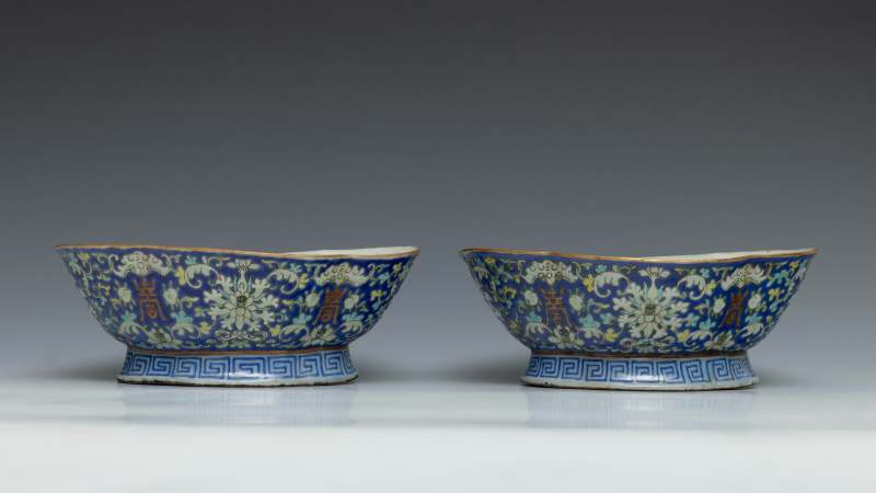 A pair of blue-ground famille rose 'lotus, bat and shou' lobed bowls on foot - 图2